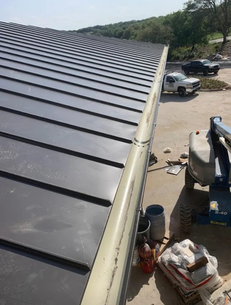 Standing seam panel and gutter detail on a metal roofing jobsite in Northvale